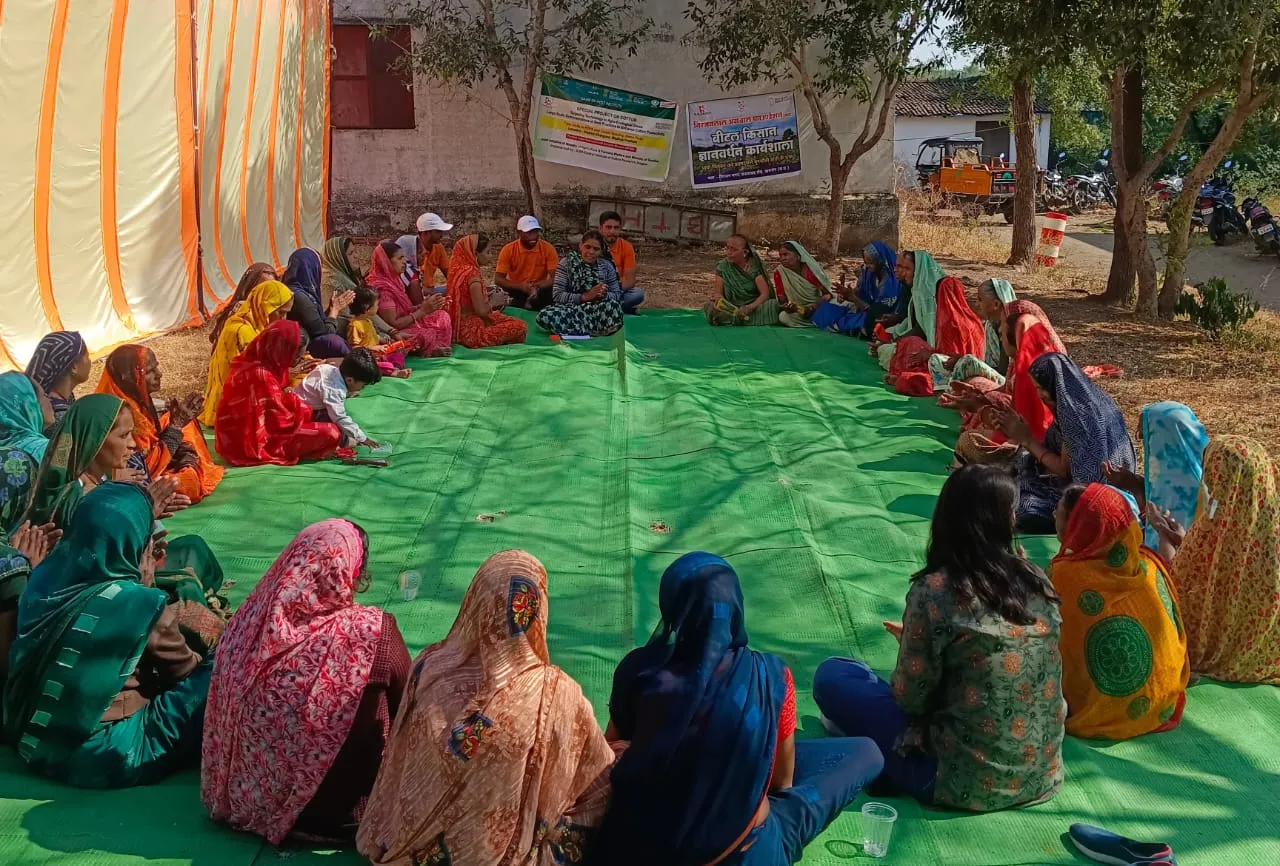 Women farmers attending a training session in a village community meeting
